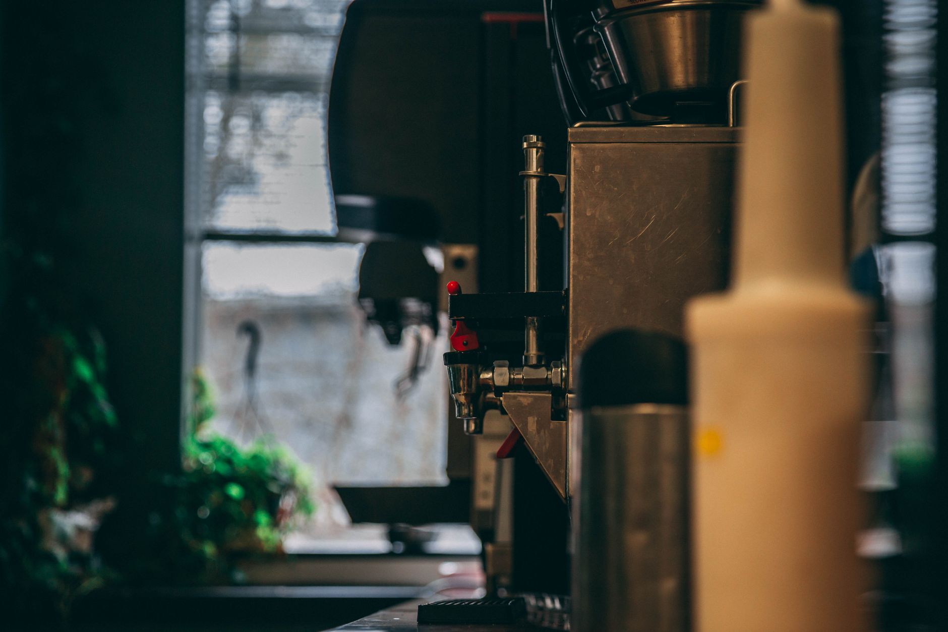 A sleek coffee machine in a softly lit cafe. Ideal for coffee shop themes.