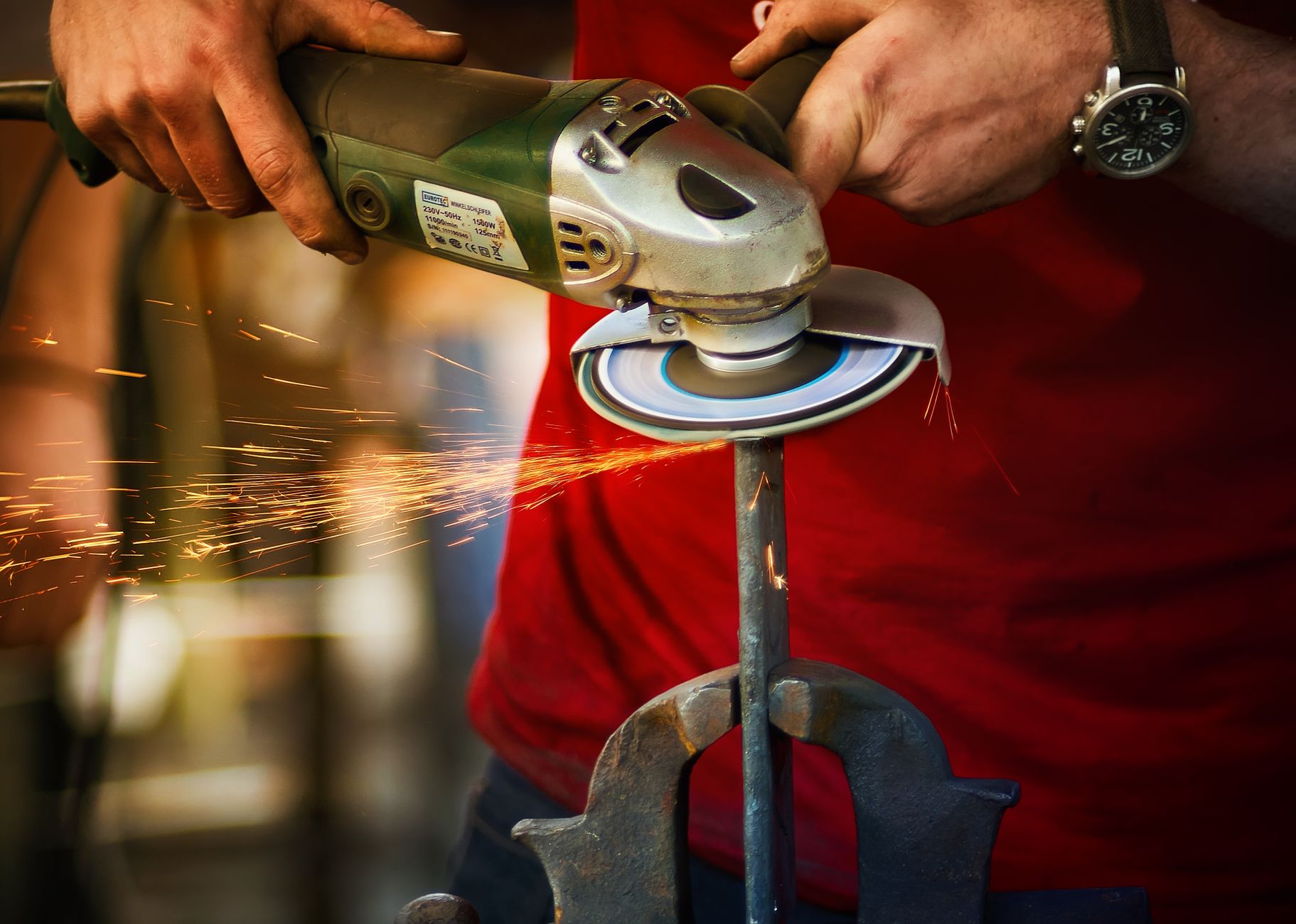 Close-up of a worker using an angle grinder with sparks flying, showcasing precision and craftsmanship.