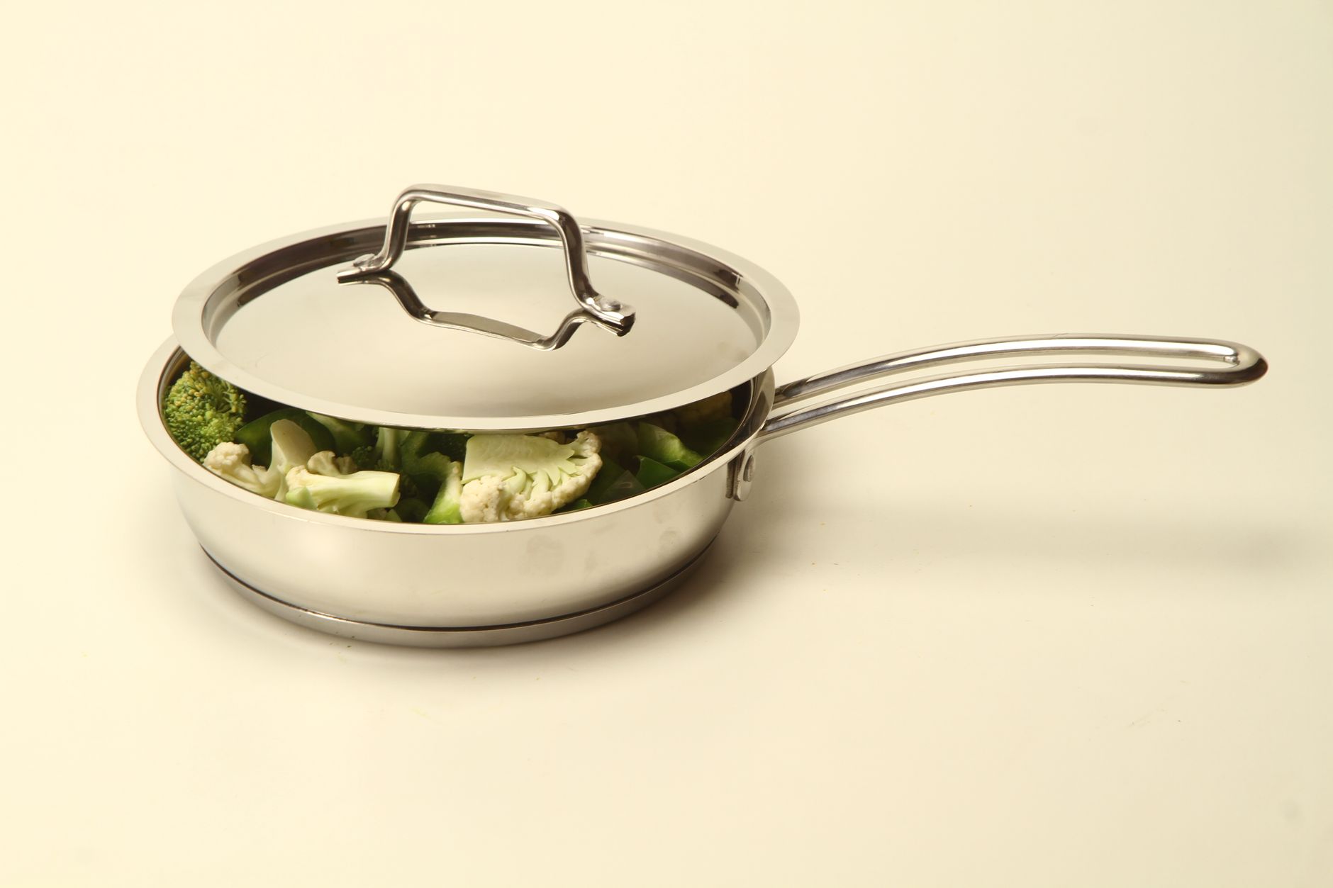Modern stainless steel pan with vegetables, ideal for healthy cooking.