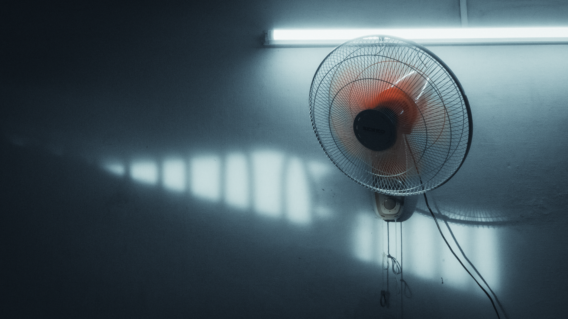 A serene interior scene with a wall-mounted fan and soft lighting in Ho Chi Minh City, Vietnam.