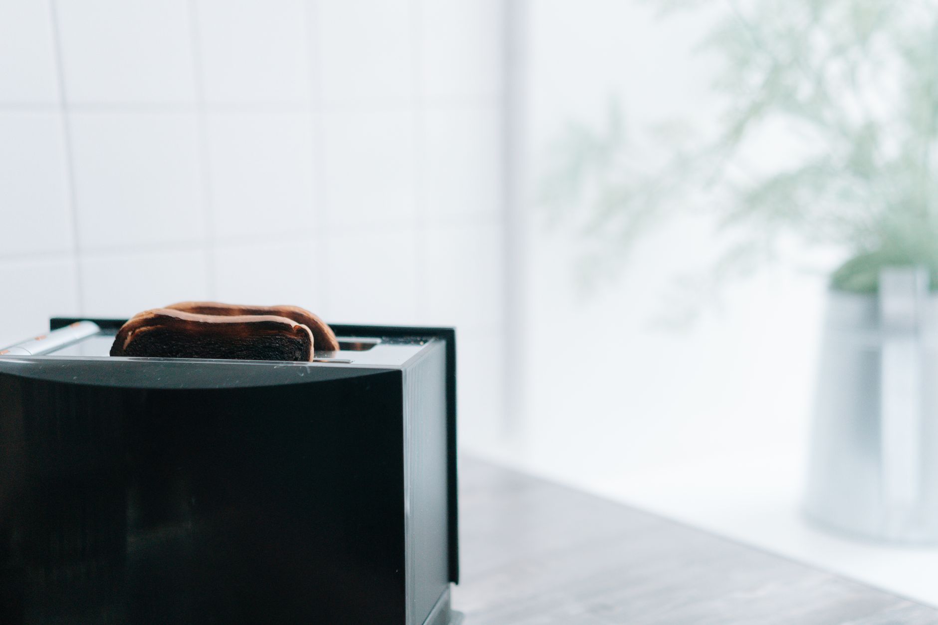 A close-up of freshly toasted bread popping from a sleek black toaster